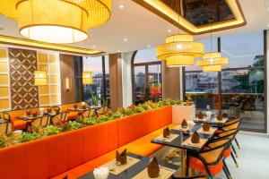 a restaurant with tables and chairs and large windows at Lé Blend Residence in Krong Poi Pet