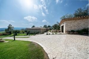 a stone driveway leading to a house with a building at La Bastide des Rameaux - Boutique Hôtel & Spa in Callas