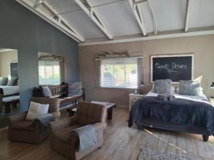 a bedroom with a bed and two chairs and a table at Myplekki in Bethlehem