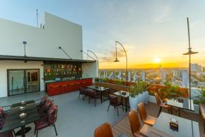 a rooftop bar with tables and chairs on a building at Lé Blend Residence in Krong Poi Pet