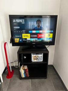 una TV a schermo piatto appoggiata su un mobiletto di intrattenimento nero di Ciotat Cherry - au coeur de La Ciotat à 2 pas du port a La Ciotat Altre 5 foto