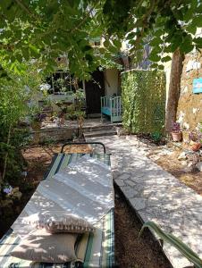 a bench sitting in a garden under a tree at Casa Natasa in Oziás