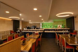 a restaurant with wooden tables and chairs and a kitchen at Jounieh Suites Boutique Hotel in Jounieh