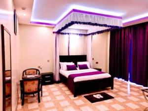 a bedroom with a bed with a purple canopy at Rubax motel mbarara in Mbarara