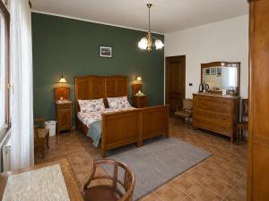 a bedroom with a bed and a dresser and a chair at Ca'Mia - Rooms in Porto Tolle