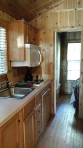 a kitchen with wooden cabinets and a sink at Snowflower Camping Resort Cabin 3 in Emigrant Gap