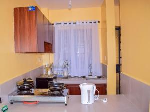 a kitchen with a counter top with pots and pans at Lucci suites in Kisumu +2 photos