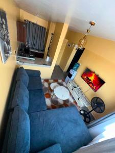 a living room with a blue couch and a television at Lucci suites in Kisumu