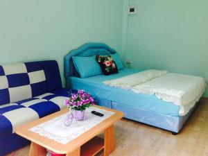 a living room with a couch and a table with flowers at MAIYOK in Ko Si Chang