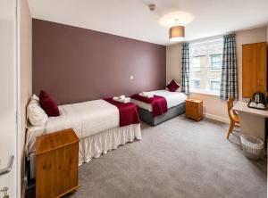 a hotel room with two beds and a window at Hampton Hotel in Llandrindod Wells