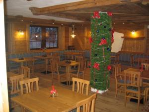 a christmas tree in the middle of a restaurant at Chalet Degli Angeli in Folgarida +38 photos
