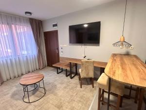 a dining room with a table and a television on the wall at Clepsydra Residence in Plovdiv