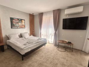 a bedroom with a bed and a large window at Clepsydra Residence in Plovdiv