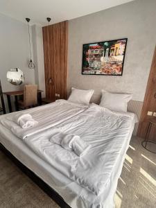 a large white bed with two towels on it at Clepsydra Residence in Plovdiv