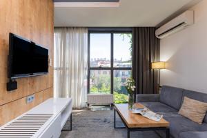 ein Wohnzimmer mit Sofa und Fernseher in der Unterkunft Alpha by Horizon Hotels, Yerevan in Yerevan