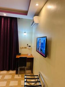 a room with a table and a tv on the wall at Rubax motel mbarara in Mbarara