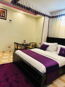 a bedroom with a large bed and a table at Rubax motel mbarara in Mbarara