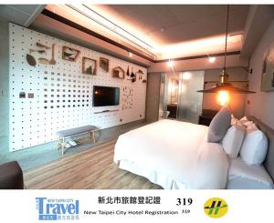 a bedroom with a white bed and a tv on a wall at Thinker Hotel in Yingge