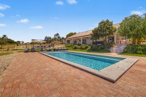 a swimming pool in front of a house at Monte Do Poço Country House in Erra