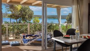 a dining room with a view of the ocean at Mobile Homes Lopari in Nerezine