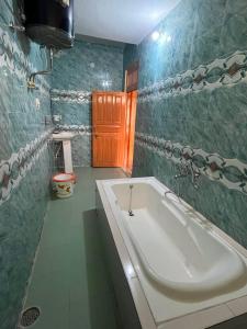 a bathroom with a large white tub in a room at DELTA Inn HOMESTAY in Khashdhār