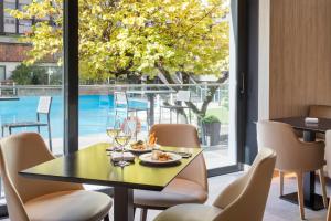 a dining room with a table and chairs and a large window at Meliá Castilla in Madrid