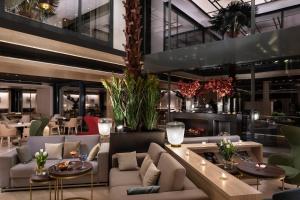 a restaurant with couches and tables and chairs at Meliá Castilla in Madrid +113 photos
