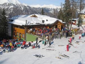 a crowd of people standing outside of a ski lodge at Chalet Degli Angeli in Folgarida