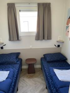 a room with two beds and a window at Waddenlodge Exclusive in Harlingen