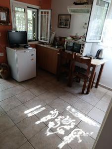 a kitchen with a refrigerator and a table with a microwave at Casa Natasa in Oziás