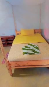 a bed with a wooden frame with a green towel on it at Essie Rovers Camp in Talek