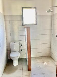 a bathroom with a toilet and a window at Villa Masoandro in Sainte Marie