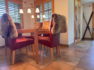a dining room table with fur covered chairs and a table with a table at Tgèsa Staziun in Sedrun