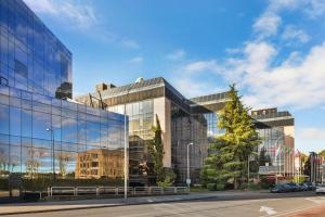 a glass building with a tree in front of it at Meliá Avenida América in Madrid