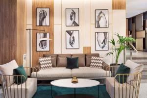 a living room with a couch and two chairs at Meliá Avenida América in Madrid