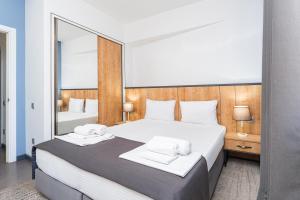 ein Schlafzimmer mit einem großen Bett und einem großen Spiegel in der Unterkunft Alpha by Horizon Hotels, Yerevan in Yerevan