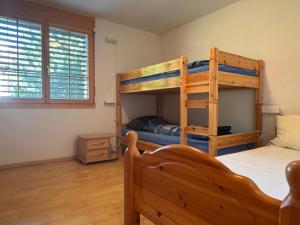 a bedroom with two bunk beds in a room at Tgèsa Staziun in Sedrun