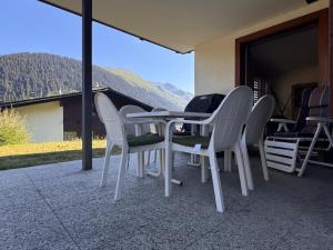a table and chairs on a patio with a view at Tgèsa Staziun in Sedrun