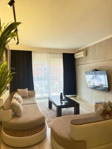 a living room with two couches and a tv at Prishtina Escape Apartments - Luxury & Modern Apartment in Prishtinë