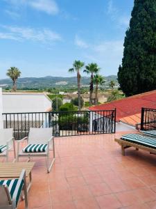 a patio with two benches and palm trees at B&B Casa Ellie in Tormos +38 photos