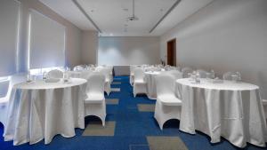 a conference room with white tables and white chairs at Jarzez Inn Hotel Azaiba فندق جرزيز إن العذيبة in Muscat +85 photos