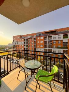 a balcony with a table and chairs on a balcony at Prishtina Escape Apartments - Luxury & Modern Apartment in Prishtinë