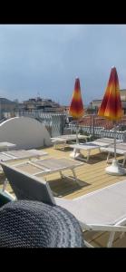 a group of lounge chairs and umbrellas on a deck at HOTEL AURORA in Cattolica