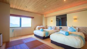 a bedroom with two beds and a large window at Livemax Resort Mihara Onsen Seafront in Mihara +97 photos