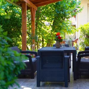 a blue table and chairs with a vase of flowers on it at Vár-Lak Nagymaros in Nagymaros