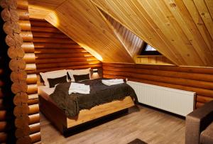 a bedroom with a bed in a wooden room at Готель Кумир in Rivne