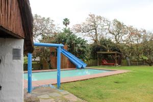 a blue slide in a pool in a yard at Hole in the Wall - Unit H1 in KuGqangushe