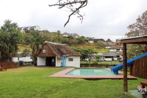 a backyard with a pool and a house at Hole in the Wall - Unit H1 in KuGqangushe