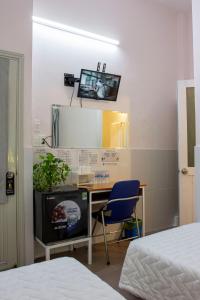 a bedroom with a desk and a tv on the wall at QUANG SAIGON Hotel- 40-7 Bùi Viện-Walking street in Ho Chi Minh City
