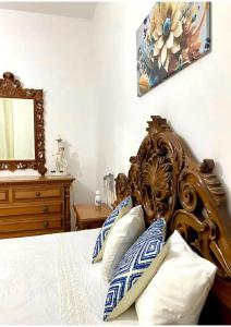 a bedroom with a wooden bed with blue and white pillows at Grace's Blue corner in Marconia